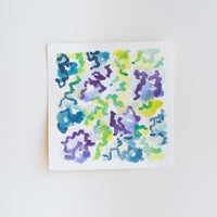 An abstract watercolor painting of flowers on paper.