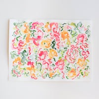 An abstract watercolor painting of flowers on paper.