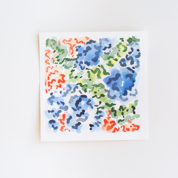 An abstract watercolor painting of flowers on paper.